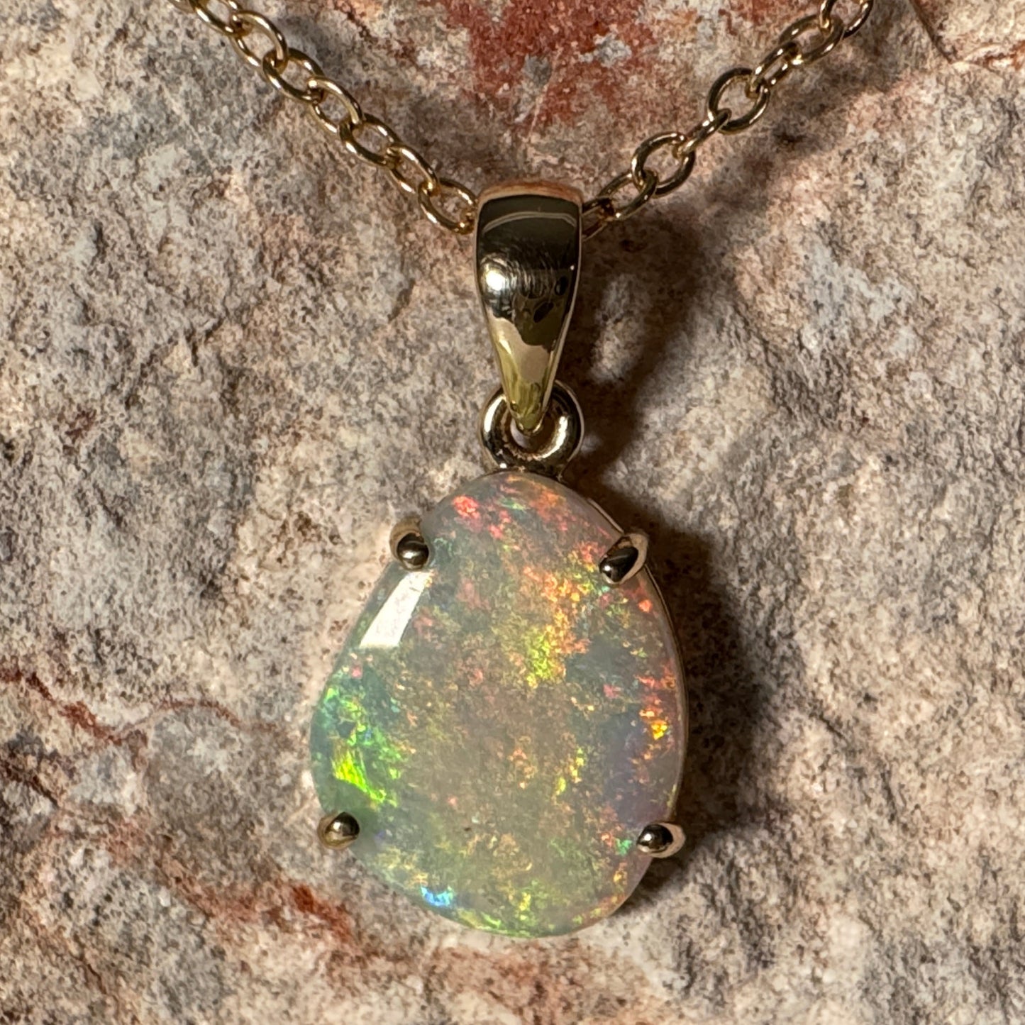 Opal pendant necklace on a stone background