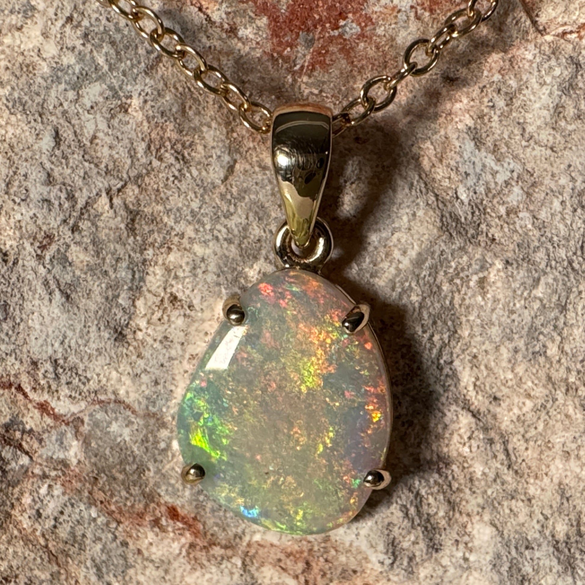Opal pendant necklace on a stone background