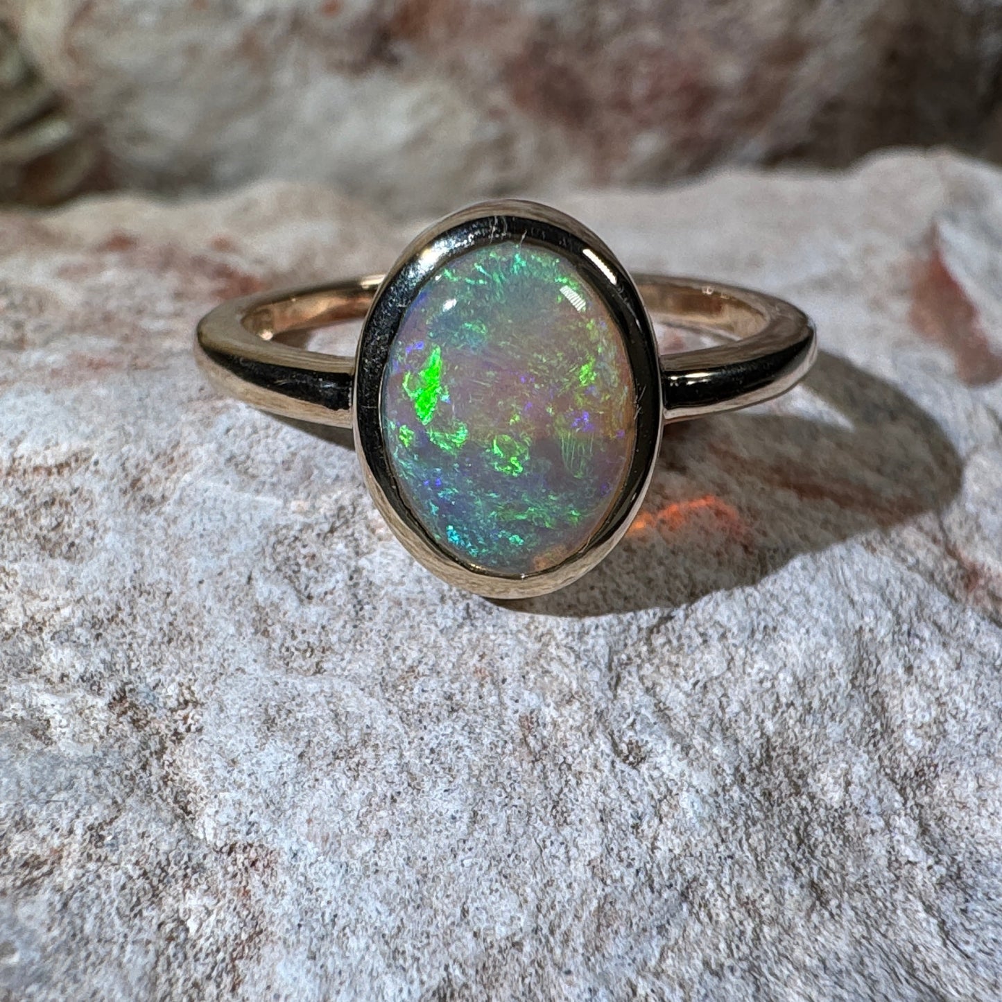 Opal ring on a textured stone surface